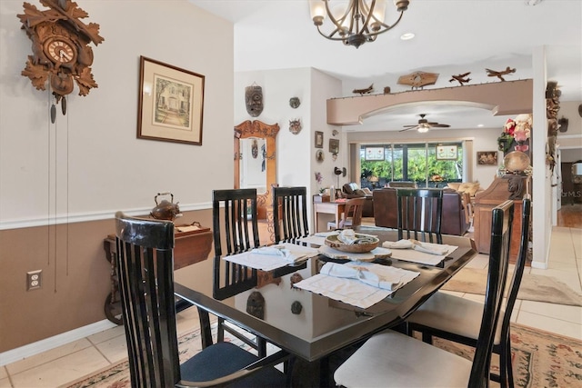 dining area featuring light tile patterned floors and ceiling fan with notable chandelier