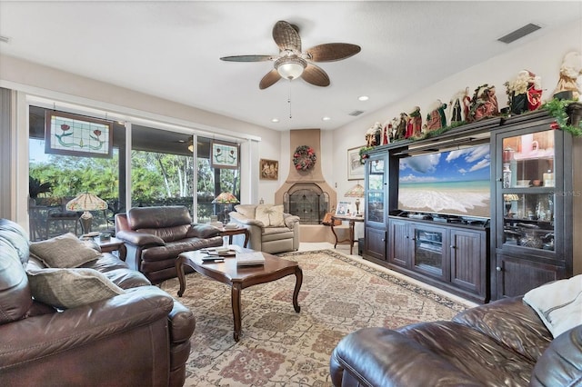 living room with a large fireplace and ceiling fan