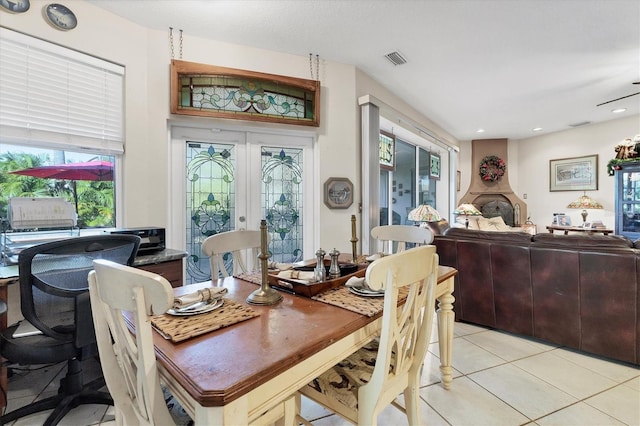 dining area with french doors, a healthy amount of sunlight, and light tile patterned flooring