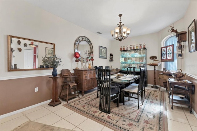 tiled dining room with a notable chandelier