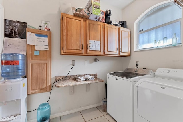 washroom with cabinets, light tile patterned floors, and washer and clothes dryer