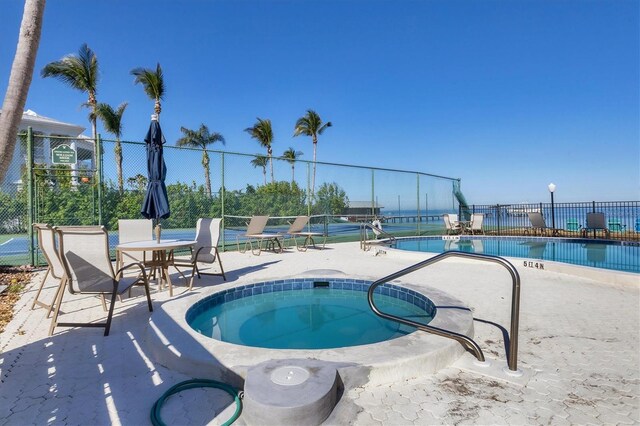 view of swimming pool featuring a patio and a hot tub