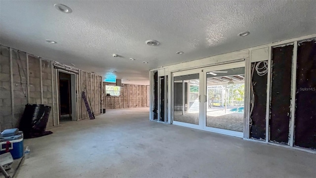 spare room featuring concrete floors and a textured ceiling