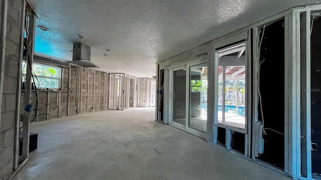 hallway with concrete flooring and a textured ceiling