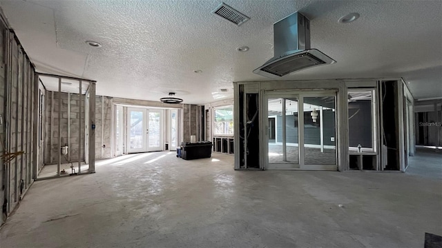 misc room with french doors, concrete floors, and a textured ceiling