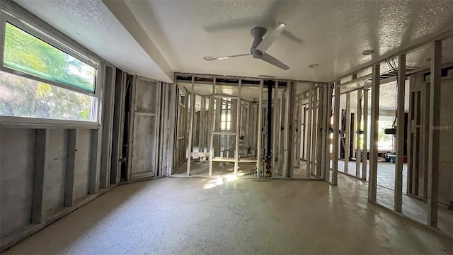 miscellaneous room featuring ceiling fan and a textured ceiling