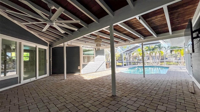 view of pool with glass enclosure, ceiling fan, and a patio