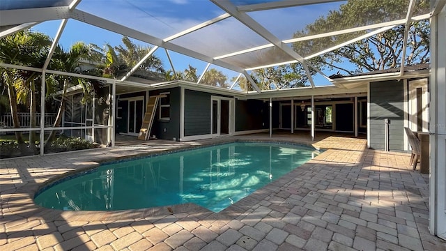 view of pool with glass enclosure and a patio