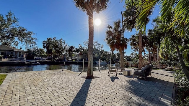 view of patio with a water view and a dock