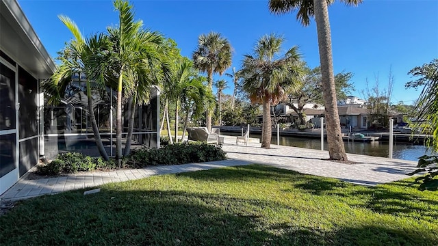 view of yard with a sunroom and a water view