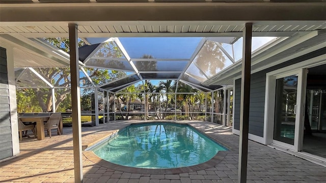 view of pool featuring glass enclosure and a patio area