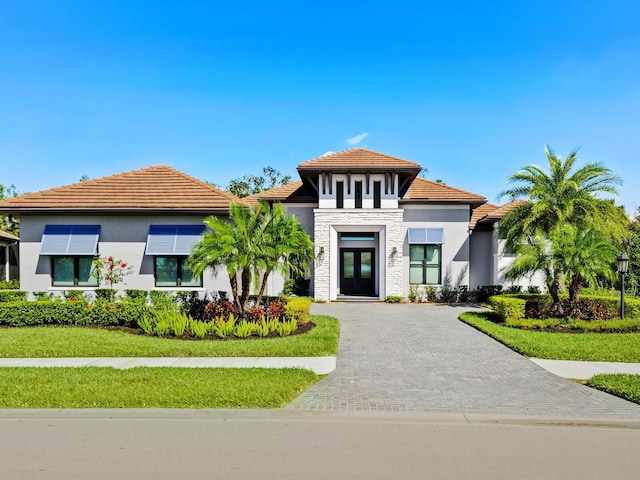 view of front of house with french doors and a front lawn