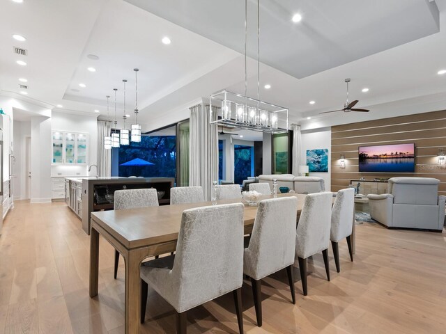 dining area featuring light hardwood / wood-style flooring, ceiling fan, and sink