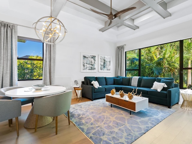 living room with beam ceiling, plenty of natural light, wood-type flooring, and ceiling fan with notable chandelier