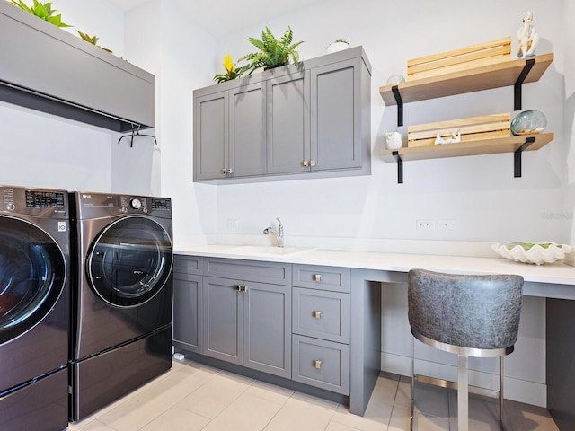 laundry room with light tile patterned flooring, cabinets, sink, and washing machine and dryer