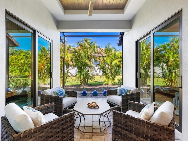 sunroom / solarium featuring beamed ceiling, wood ceiling, a wealth of natural light, and a tray ceiling