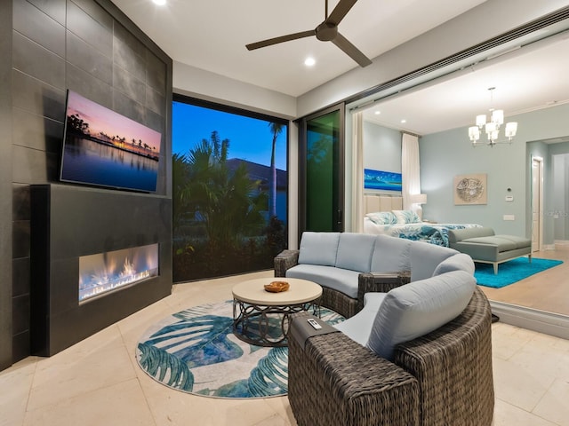 tiled living room with a tile fireplace and ceiling fan with notable chandelier