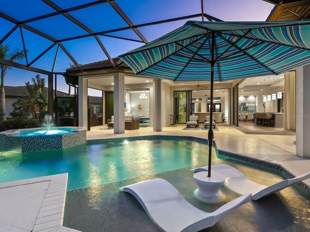 pool at dusk featuring glass enclosure, an outdoor hangout area, pool water feature, an in ground hot tub, and a patio area