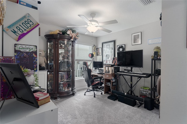 carpeted office space featuring ceiling fan