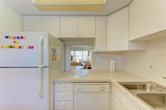 kitchen featuring white cabinets, white appliances, sink, and tasteful backsplash