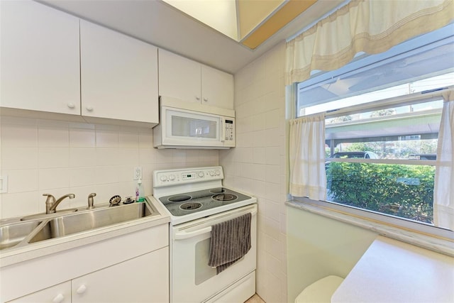 kitchen with backsplash, white cabinetry, white appliances, and sink