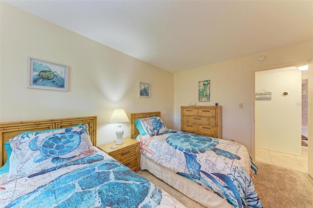 bedroom featuring light colored carpet and a textured ceiling