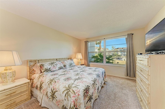 bedroom featuring light colored carpet and a textured ceiling