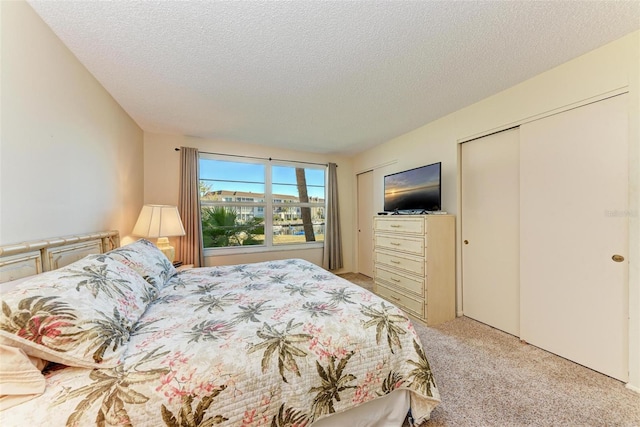 carpeted bedroom with a textured ceiling and a closet