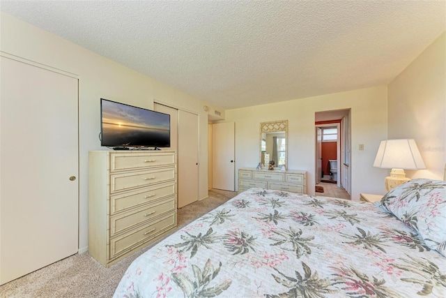 bedroom with light colored carpet, a textured ceiling, and a closet