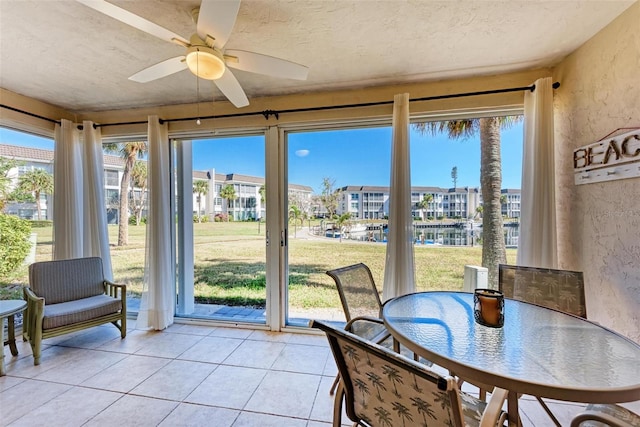 sunroom featuring ceiling fan and plenty of natural light