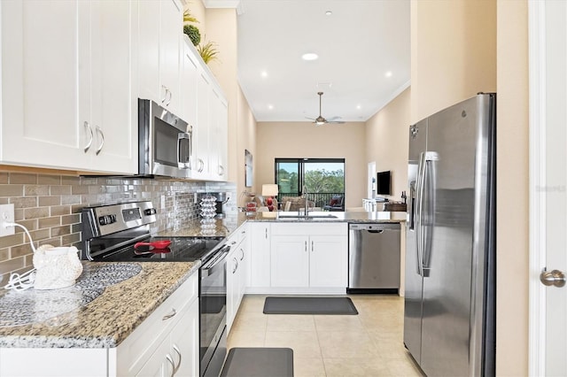 kitchen featuring light stone countertops, white cabinets, and stainless steel appliances