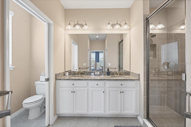 bathroom featuring tile patterned flooring, vanity, toilet, and a shower with shower door