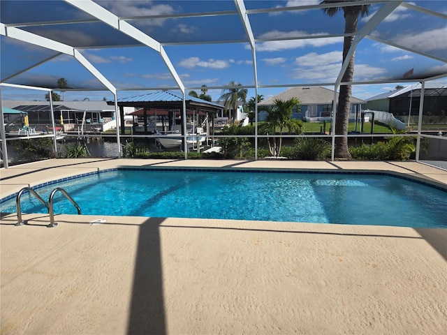 view of pool with glass enclosure, a patio area, and a water view