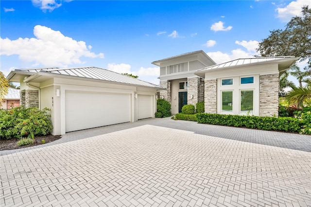 931 Bayshore Rd, Nokomis, FL 34275 - prairie-style house featuring a standing seam roof, stone siding, decorative driveway, an attached garage, and metal roof