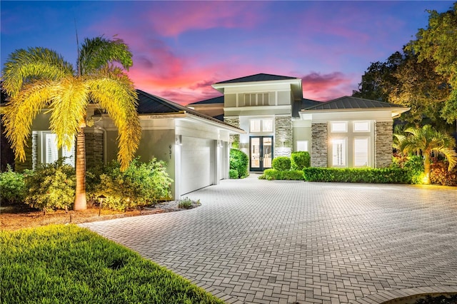 931 Bayshore Rd, Nokomis, FL 34275 - view of front of property with stone siding, a garage, french doors, driveway, and stucco siding