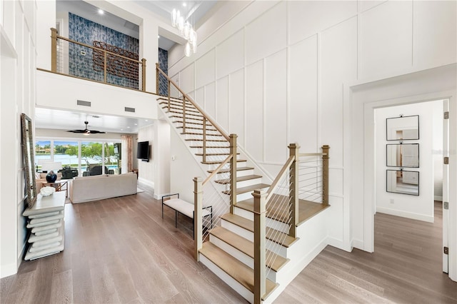 931 Bayshore Rd, Nokomis, FL 34275 - staircase featuring wood finished floors, a towering ceiling, baseboards, and a decorative wall