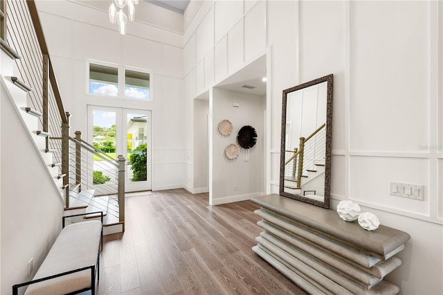 foyer featuring french doors, a high ceiling, and light wood-type flooring