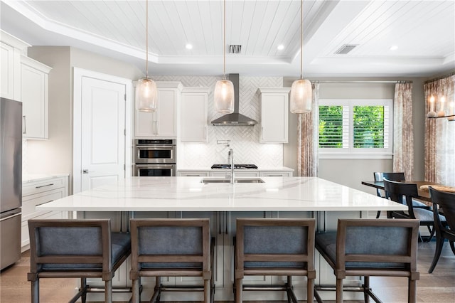 931 Bayshore Rd, Nokomis, FL 34275 - kitchen featuring wall chimney exhaust hood, a tray ceiling, stainless steel appliances, decorative backsplash, and recessed lighting