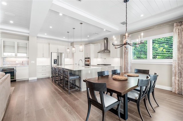 931 Bayshore Rd, Nokomis, FL 34275 - dining room with wine cooler, wood finished floors, a chandelier, recessed lighting, and a raised ceiling