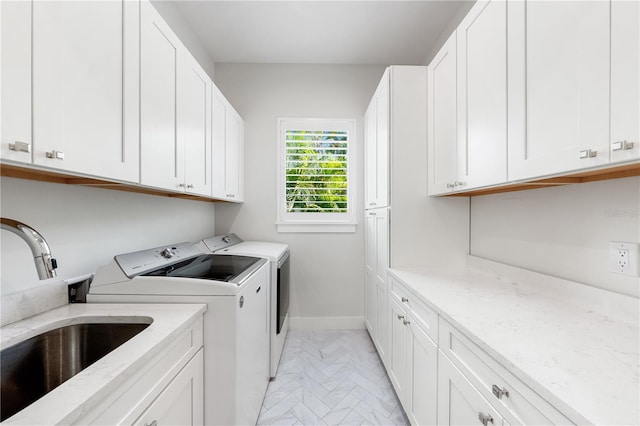 laundry room with cabinets, separate washer and dryer, and sink