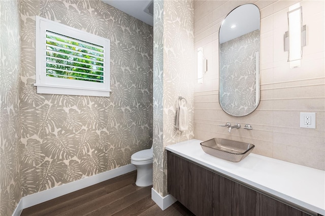 bathroom with toilet, vanity, and hardwood / wood-style flooring