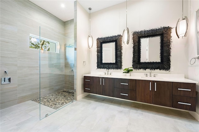 bathroom with a tile shower and vanity