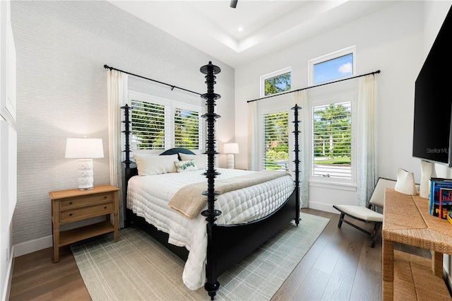 931 Bayshore Rd, Nokomis, FL 34275 - bedroom featuring wood finished floors, baseboards, a towering ceiling, and a tray ceiling