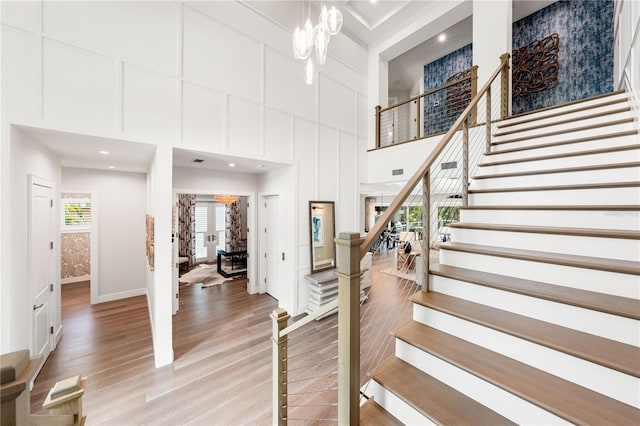 931 Bayshore Rd, Nokomis, FL 34275 - staircase featuring a towering ceiling, wood finished floors, baseboards, a chandelier, and recessed lighting