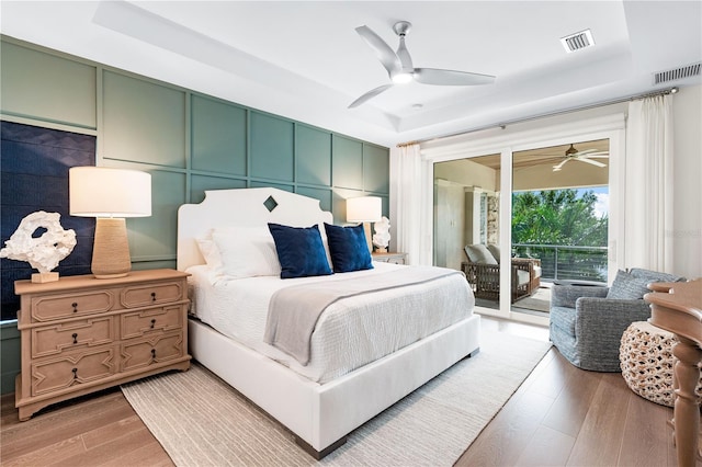 931 Bayshore Rd, Nokomis, FL 34275 - bedroom featuring light wood-type flooring, access to exterior, a tray ceiling, and a ceiling fan