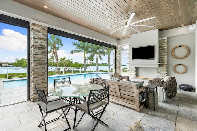 view of patio with an outdoor living space with a fireplace, ceiling fan, and a fenced in pool