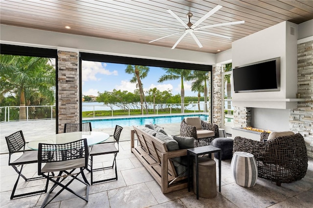 view of patio / terrace featuring an outdoor living space with a fireplace, ceiling fan, and a fenced in pool