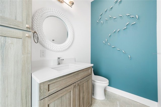 bathroom with tile patterned flooring, vanity, and toilet