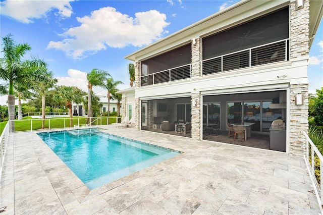 rear view of property with ceiling fan, a yard, and a patio