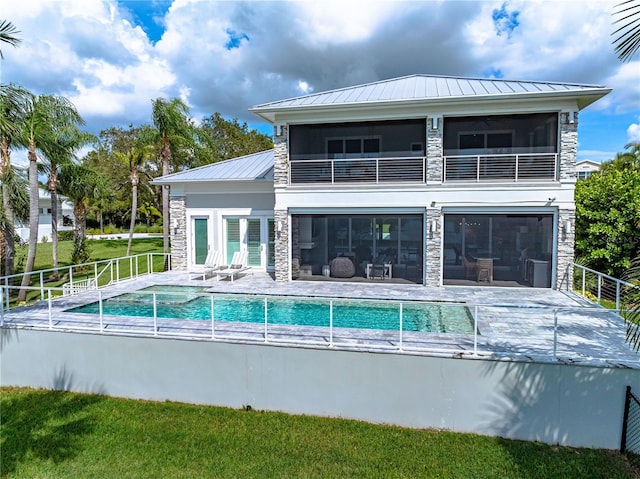 931 Bayshore Rd, Nokomis, FL 34275 - rear view of house with stone siding, a standing seam roof, a balcony, and metal roof